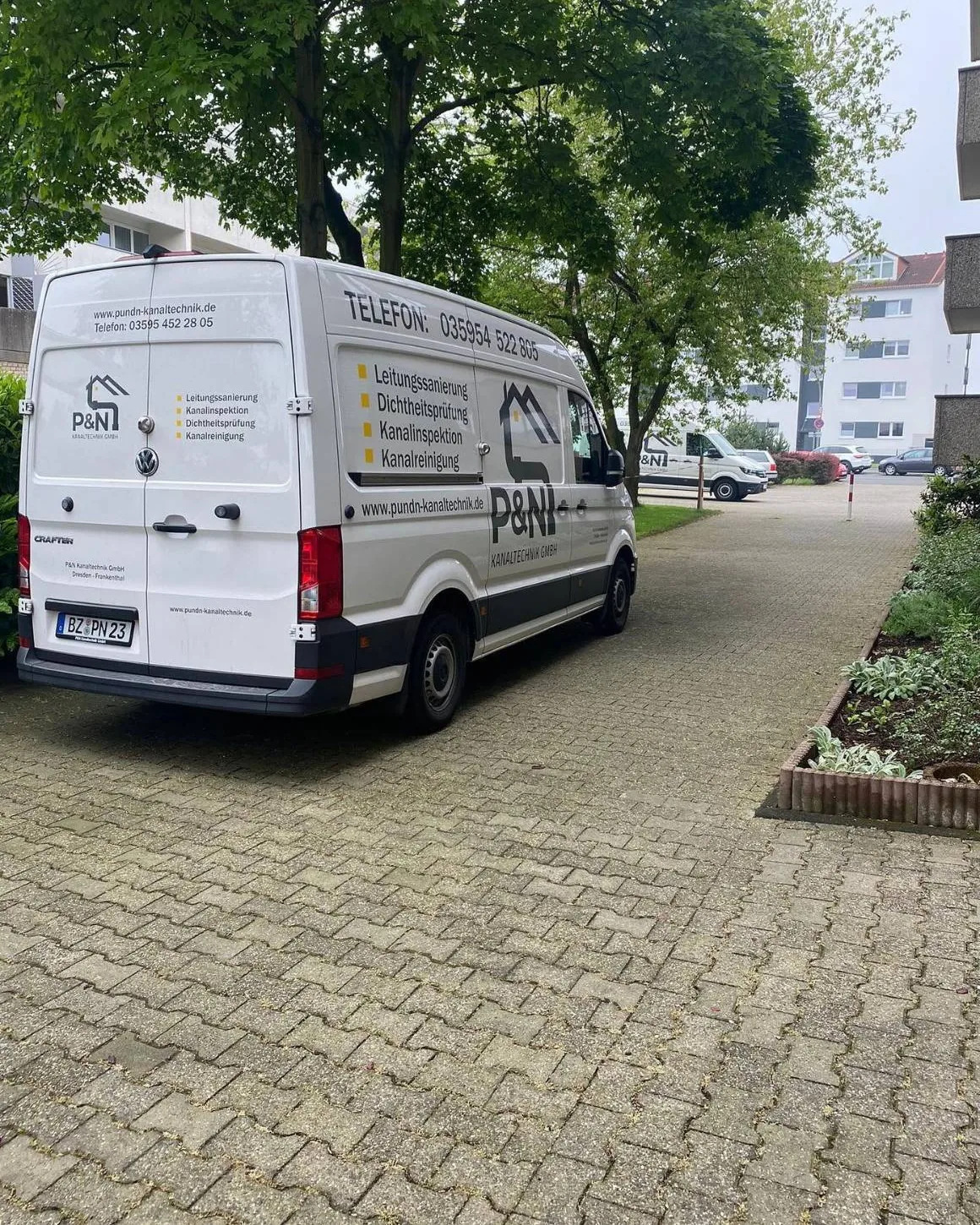 Fahrzeug der P&N Kanaltechnik GmbH zwischen Wohngebäuden