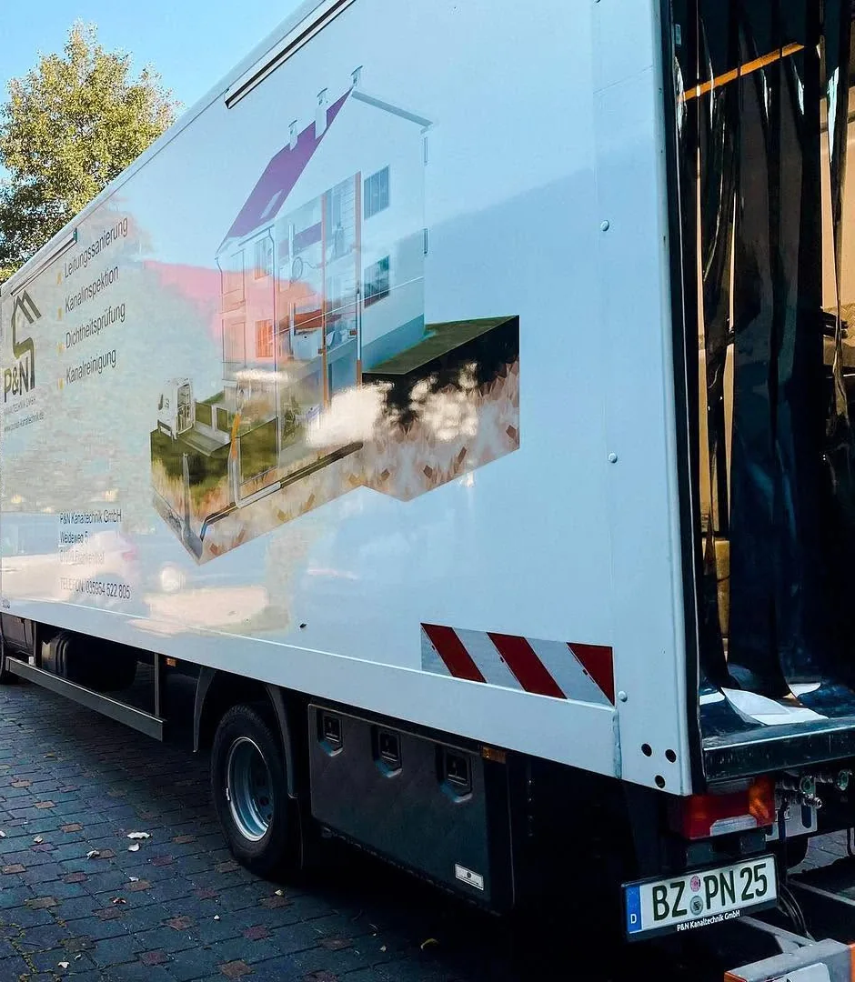 Lkw des Partnerbetriebs P&N mit Sanierungstechnik in einer Hofeinfahrt